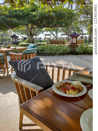 Breakfast table at Asian resort. Pancakes, sandwiches, coffee, juices, salad, fresh fruits. Healthy, delicious dishes on a sunny Bali vacation. 123403465