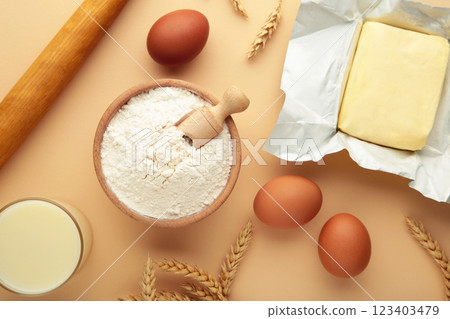 Ingredients for baking or cooking, egg flour, rolling pin butter, milk on a beige background Cookie pie or cake recipe. Ingredients for baking or cooking, egg flour, rolling pin butter, milk on a beige background Cookie pie or cake recipe. 123403479