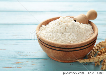 Wooden bowl with flour and flour spoon. Rice or wheat flour on blue wooden background. top view Wooden bowl with flour and flour spoon. Rice or wheat flour on blue wooden background. top view 123403480
