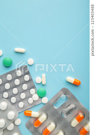 Supplements and pills blister packs on blue background. Pharmacists and clinics. Vertical photo. Supplements and pills blister packs on blue background. Pharmacists and clinics. Vertical photo. 123403488