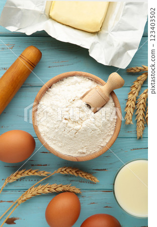 Ingredients for baking or cooking, egg flour, rolling pin butter, milk on a blue wooden background Cookie pie or cake recipe. Ingredients for baking or cooking, egg flour, rolling pin butter, milk on a blue wooden background Cookie pie or cake recipe. 123403502