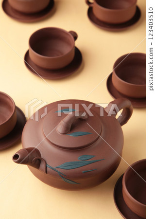 Clay teapot with cups on beige background. Clay teapot with cups on beige background. 123403510