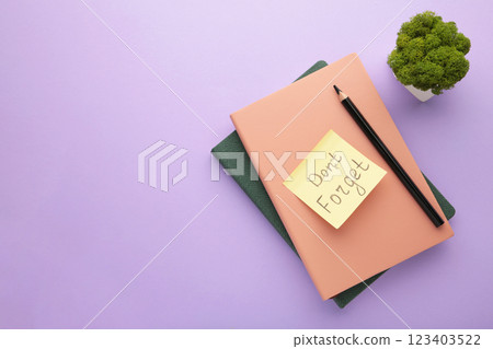 Notepad and sticky notes with word don't forget on purple background. Notepad and sticky notes with word don't forget on purple background. 123403522