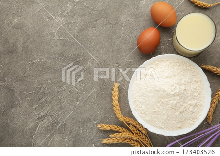 Ingredients for baking or cooking, egg flour, rolling pin butter, milk on a grey background Cookie pie or cake recipe. 123403526