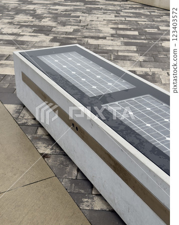Modern urban solar-powered smart bench on tiled pavement. Modern urban solar-powered smart bench on tiled pavement. 123403572