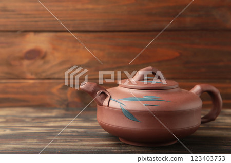 Clay teapot on brown wooden background. Space for text Clay teapot on brown wooden background. Space for text 123403753