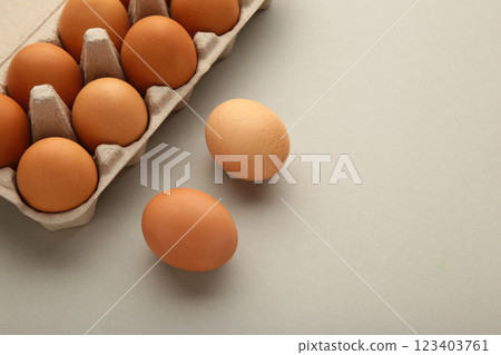 Chicken eggs in an open egg carton on grey. Top view with copy space. Natural healthy food and organic farming concept. 123403761