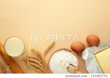 Ingredients for baking or cooking, egg flour, rolling pin butter, milk on a beige background Cookie pie or cake recipe. Ingredients for baking or cooking, egg flour, rolling pin butter, milk on a beige background Cookie pie or cake recipe. 123403778