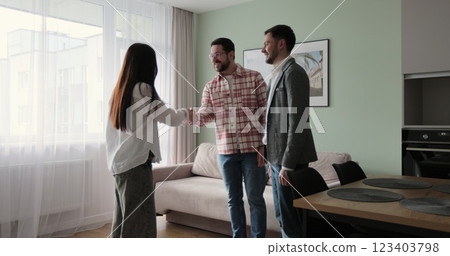 Real estate agent is giving keys to buyers of new apartment, man is shaking hands with woman realtor. Real estate agent is giving keys to buyers of new apartment, man is shaking hands with woman realtor. 123403798