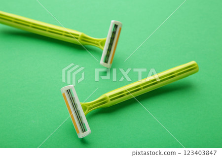 Green razors for hair removal on green background 123403847