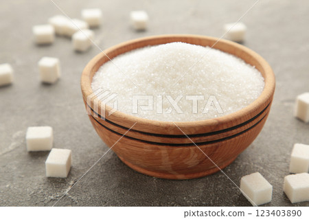 Bowl with white sand and lump sugar on grey background 123403890