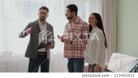 Back view of young family choosing new house or apartment, meeting with real estate agent, trying to take decision and make right choice of accommodation. Real estate concept. 123403912