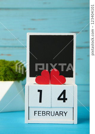 Wooden calendar with date of February 14 on blue background. Valentine Day 123404101