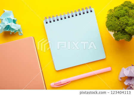 A notebook with a blank page and pen on yellow background. Copy space, layout, mockup. 123404113