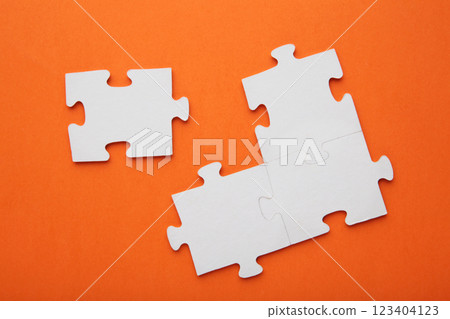Four white puzzle pieces on orange background 123404123