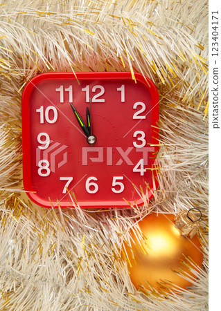 New Year's clock decorated with christmas tinsel. Celebration Concept for New Year Eve. New Year's clock decorated with christmas tinsel. Celebration Concept for New Year Eve. 123404171