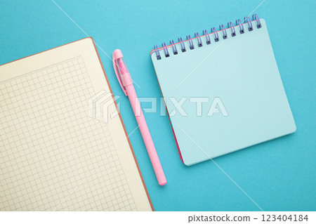 Open notebook and notebooks on blue background. Open notebook and notebooks on blue background. 123404184
