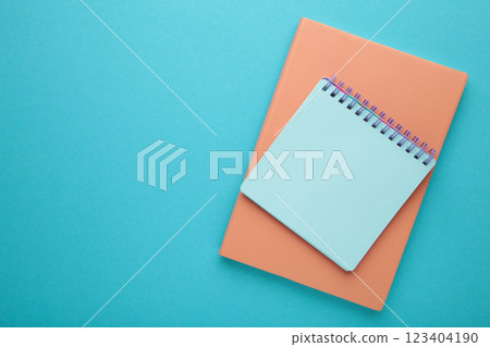 Blank paper notebook on blue background. Office desk table concept. 123404190