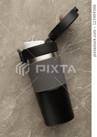 Black thermo mug on grey background. Vertical photo Black thermo mug on grey background. Vertical photo 123404306