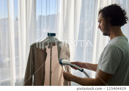Steam cleaning your garments ensures a crisp, polished finish that enhances their appearance 123404429