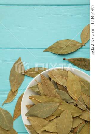 Bay leaves in bawl on blue background. Vertical photo 123404495