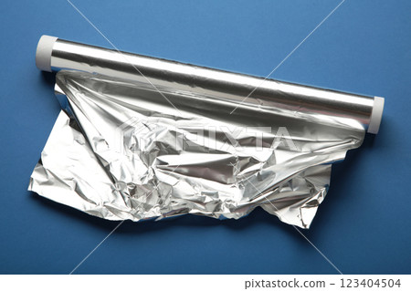 Roll of aluminum foil on dark blue background. Roll of aluminum foil on dark blue background. 123404504