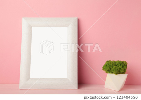 Interior design with white mock up photo frame on pink background with beautiful plants. Space for text Interior design with white mock up photo frame on pink background with beautiful plants. Space for text 123404550