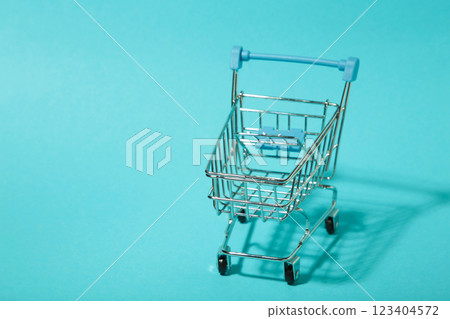 Mini shopping trolley with shadow on blue background. Top view Mini shopping trolley with shadow on blue background. Top view 123404572