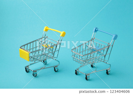 Mini shopping trolleys on blue background Mini shopping trolleys on blue background 123404606