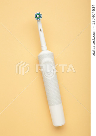 Modern electric toothbrush on beige background. Controlled tool for daily oral care. Modern electric toothbrush on beige background. Controlled tool for daily oral care. 123404634