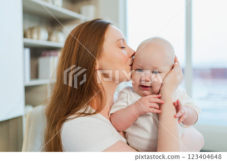 Happy family at home. Mother holding little toddler child daughter. Mom and baby girl relax playing having fun together at home. Mother hugs baby with love care. Mom of breast feeding baby Happy family at home. Mother holding little toddler child daughter. Mom and baby girl relax playing having fun together at home. Mother hugs baby with love care. Mom of breast feeding baby 123404648