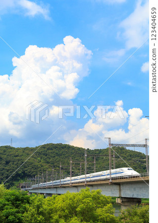 一朵積雨雲籠罩著正在穿越吉井川大橋的山陽新幹線列車 123404659
