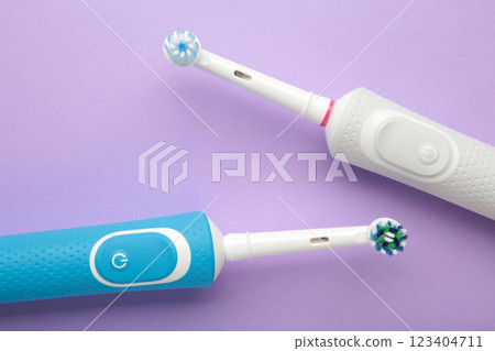 Two Modern electric toothbrushes on purple background. Top view. Teeth care. Minimalism 123404711