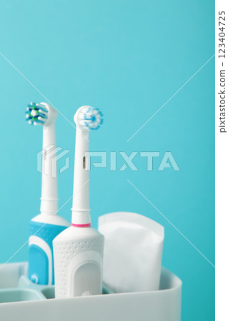 Holder with modern electric toothbrushes on blue background Holder with modern electric toothbrushes on blue background 123404725