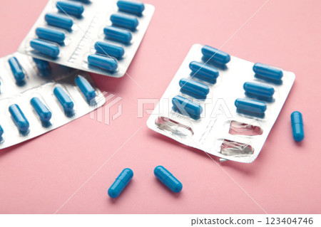 Blister pack with medicines on pink background, top view. Dietary supplements, vitamins for health and body tone. Good mood concept. 123404746