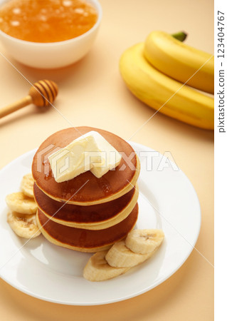 Plate with yummy banana pancakes on beige background. Vertical photo 123404767