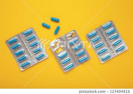 Blister pack with medicines on yellow background, top view. Dietary supplements, vitamins for health and body tone. Good mood concept. Blister pack with medicines on yellow background, top view. Dietary supplements, vitamins for health and body tone. Good mood concept. 123404818