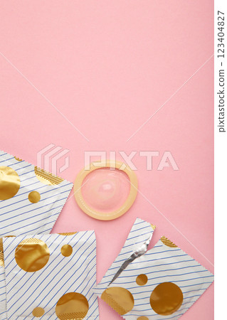 Opened condom in pack on pink background. A condom use to reduce the probability of pregnancy or sexually transmitted disease. 123404827