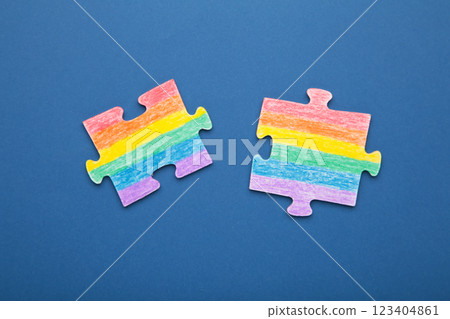 Concept LGBT as a part of society - two puzzle with the coloring of the flag of sexual minorities on dark blue background 123404861