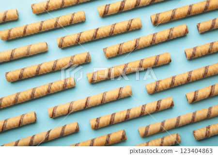 Wafer roll sticks cream rolls on blue background. Minimalism 123404863