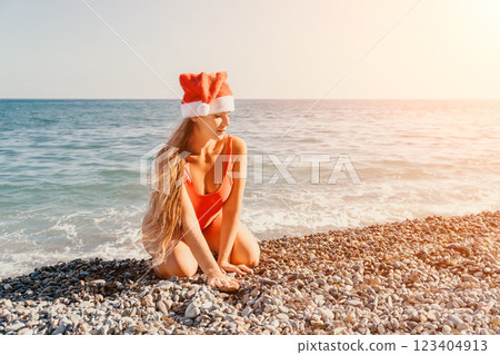 Christmas on the Beach: Woman in Santa Hat by the Sea 123404913