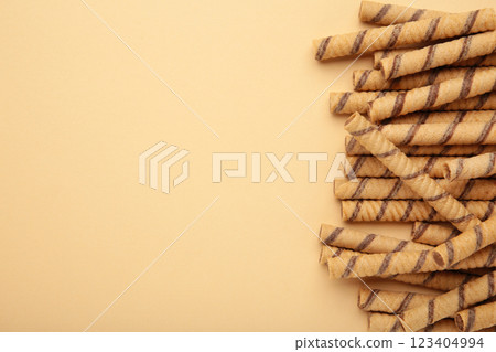 Wafer roll sticks cream rolls on beige background. Space for text Wafer roll sticks cream rolls on beige background. Space for text 123404994