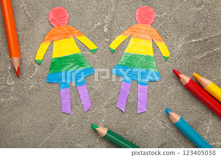 Paper women cut from paper and painted in LGBT colors with pencils. Concept of LGBT on grey background. Space for text 123405038