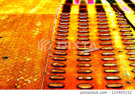 The surface of a rusty steel plate with rows of holes. Steel macro background. Changed color scheme. 123405252