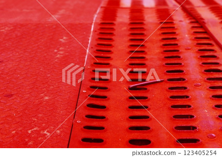 The surface of a rusty steel plate with rows of holes. Steel macro background. Changed color scheme. 123405254
