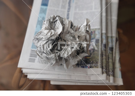 A crumpled sheet of newspaper lies on a stack of fresh newspapers, fake news, corrupt journalism. A crumpled sheet of newspaper lies on a stack of fresh newspapers, fake news, corrupt journalism. 123405303