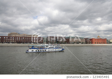Moscow, Russia - June 2022: River pleasure boat on the Moscow river and Frunzenskaya embankment. Moscow, Russia - June 2022: River pleasure boat on the Moscow river and Frunzenskaya embankment. 123405491
