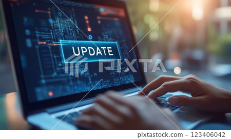 Hands are actively typing on a laptop that prominently displays an important update notification for the user 123406042