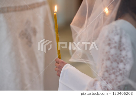 An Elegant Bride Holding a Candle During a Beautiful Wedding Ceremony Celebration Event 123406208