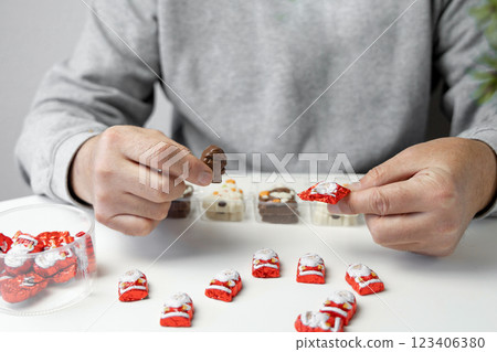 Christmas chocolates. Chocolate Christmas trees and Santa Claus. Mans hands hold chocolate. 123406380